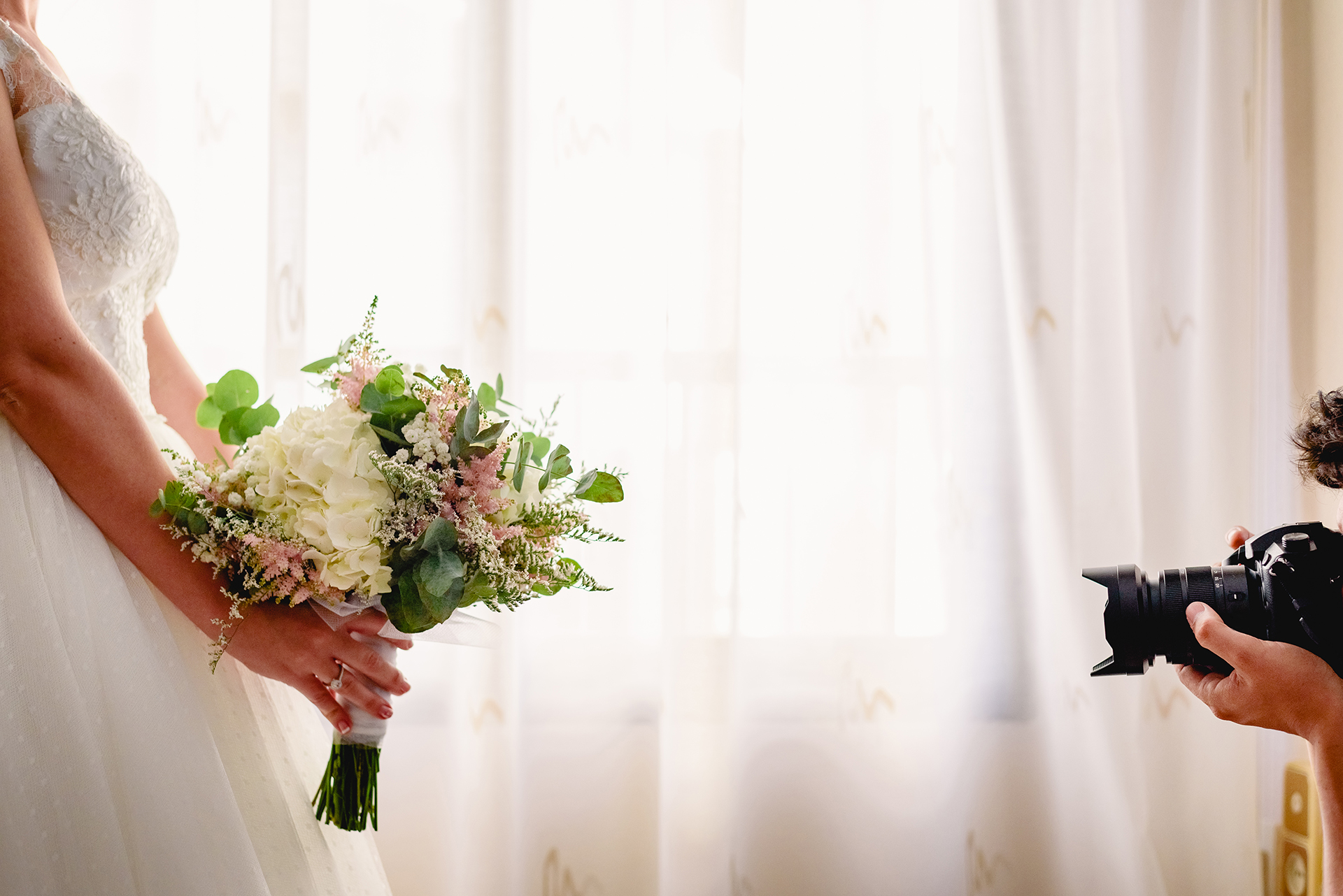 Elegant bride holding a bouquet during an indoor wedding portrait