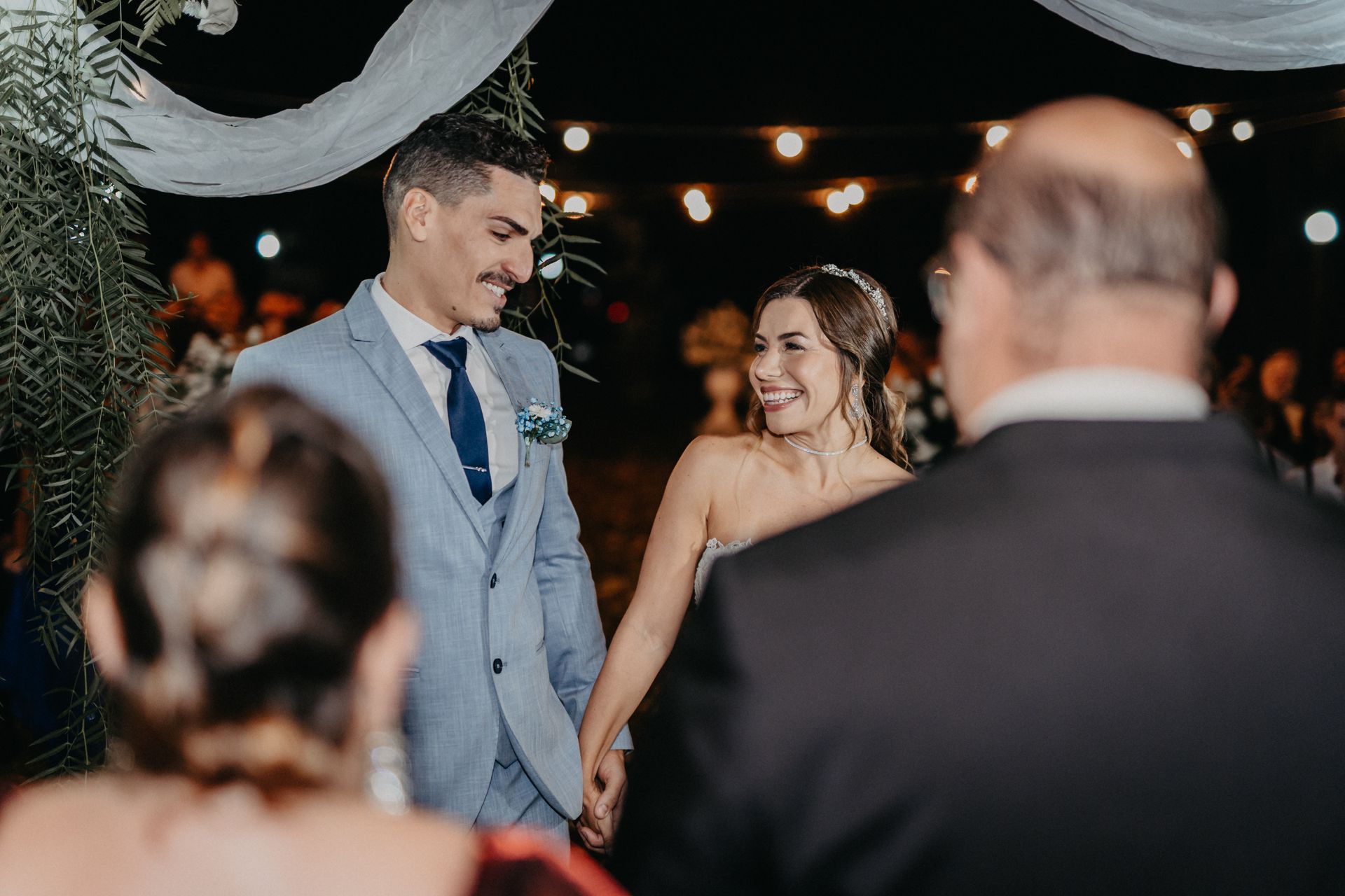 Bride and groom sharing a happy moment during an outdoor evening wedding